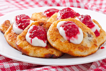Pancakes of cottage cheese with sour cream and raspberry jam