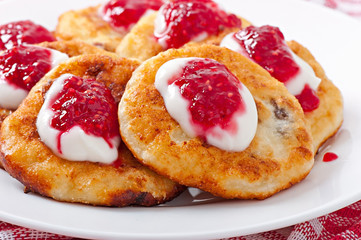 Pancakes of cottage cheese with sour cream and raspberry jam