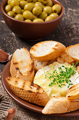 Baked Camembert cheese with thyme and toast rubbed with garlic