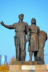Fototapeta premium Worker and farm woman statues on the green bridge