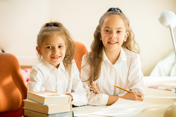 Two classmates sitting at desk and smiling