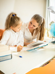Fototapeta na wymiar cute daughter doing homework with mother