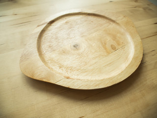 Empty wooden plate on the brown wooden table