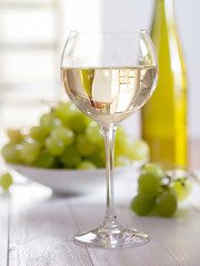 Fototapeta premium Ein Glas Weisswein mit Weintrauben