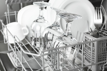 Open dishwasher with clean utensils in it