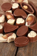 Different kinds of chocolates on wooden table close-up