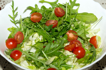 Heap of ruccola, lettuce leaves and cherry tomatoes