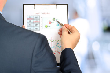 Businessman standing and showing graphics, diagram. Presentation