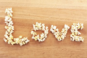 Obraz na płótnie Canvas Love word formed with popcorn on wooden table