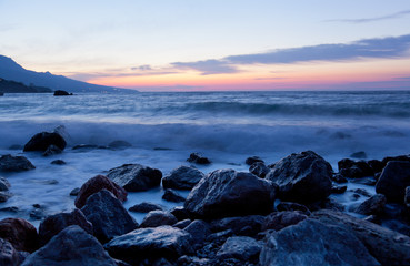 Sea landscape with stones and waves before sunrise