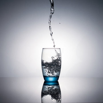 Water flowing and splashing from a glass bottle