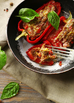 Delicious stuffed peppers in frying pan on table close-up