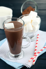 Chocolate drink with marshmallows in mug, on wooden background