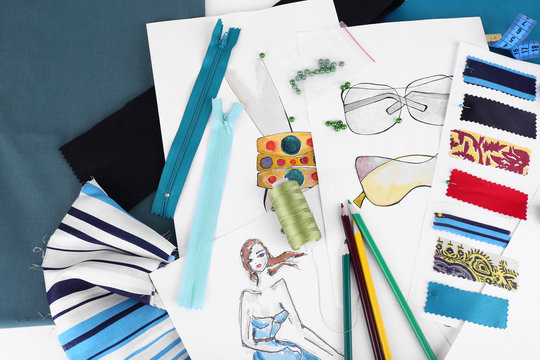 Sketches of clothes and fabric samples on table