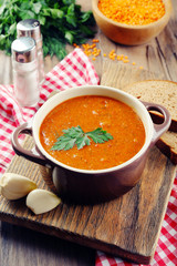 Delicious lentil cream-soup on table close-up