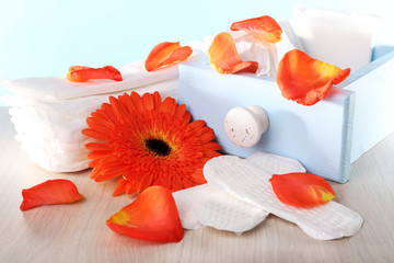 Sanitary pads in box, orange flower and rose petals