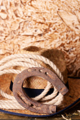 American West still life with old horseshoe, hat and cowboy