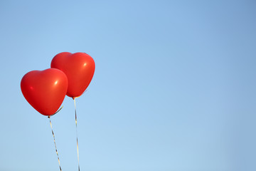 Fototapeta na wymiar Love heart balloons on sky background