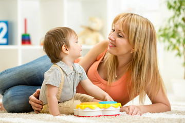 Obraz na płótnie Canvas Mother and baby boy having fun with musical toys