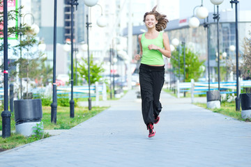 Fototapeta na wymiar Woman jogging in city street park.