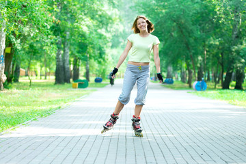 Roller skating sporty girl in park rollerblading on inline skate