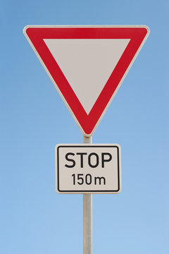 Verkehrsschild - Vorfahrt gewähren - Stop in 150 m - Himmel blau