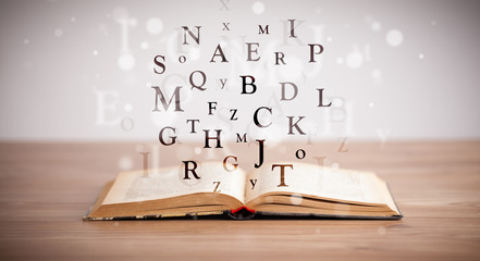 Opened book with flying letters