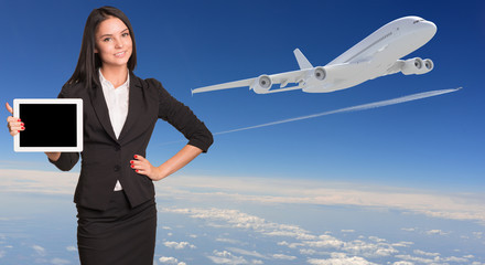 Businesswoman holding tablet pc and looking at camera