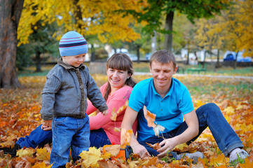 Happy family playing piggyback in autumn park