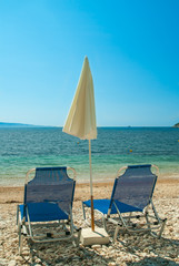 Sunbeds with umbrellas on a beautiful beach with clear water