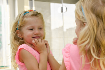 Obraz na płótnie Canvas blond girl smiling in the mirror