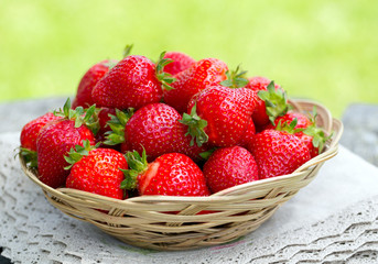 basket with strawberries on a garden wooden table