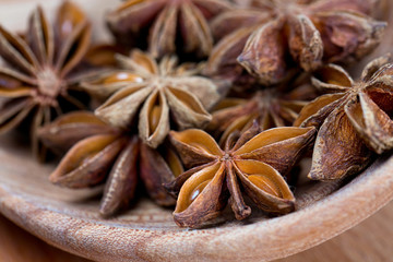 star anise in a spoon on wooden surface