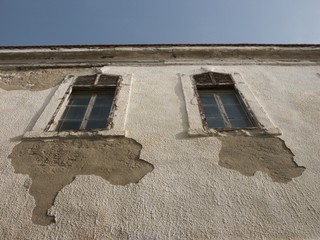 Fassade in Beige und Naturfarben mit bröckelndem Putz bei Sonnenschein in der Altstadt von Alacati...