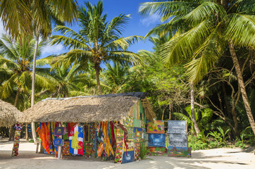 Beach with covered with a thatched roof hut with souvenirs - 71792750