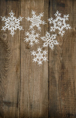 white snowflakes on wooden background. christmas decoration