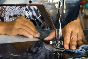 hand with crafts on the older machine repair sewing denim.