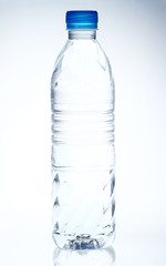 Plastic bottle of drinking water on white