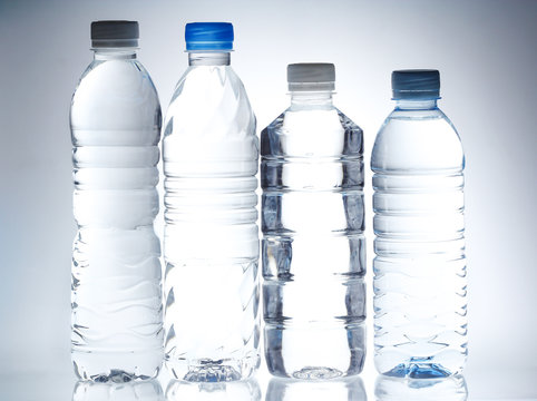 Plastic bottle of drinking water on white