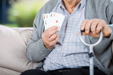 Elderly Man Showing Four Aces While Sitting