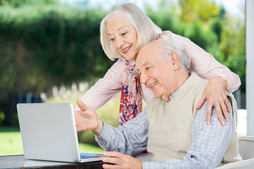 Cheerful Senior Couple Using Laptop