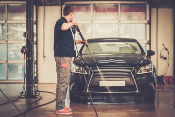 Fototapeta na wymiar Man worker washing luxury car on a car wash