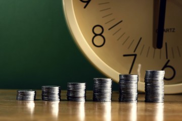 Stack of coins and a clock