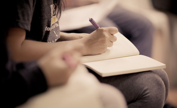 Close-up of a young girl writing into her diary