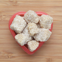 Brown cane sugars in a heart bowl