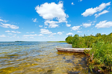 Summer lake view with wooden boat.