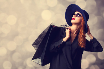 Style redhead girl with shopping bags.