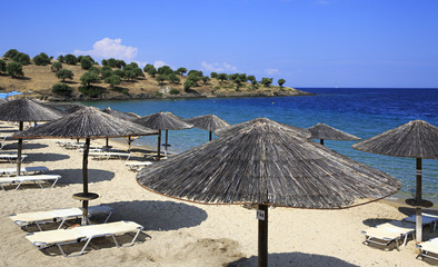 Parasols of straw on the beach of Porto Carras Grand Resort.