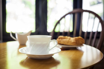 Cup of coffee and bakery on table cafe interior