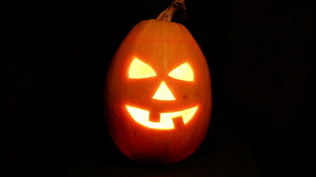 Halloween pumpkin jack-o-lantern candle lit, isolated on black